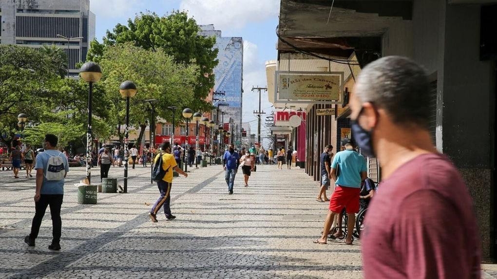 Foto da Praça do Ferreira, no Centro de Fortaleza. Pessoas passeiam usando máscara. O comércio do entorno reabrirá a partir da semana que vem
