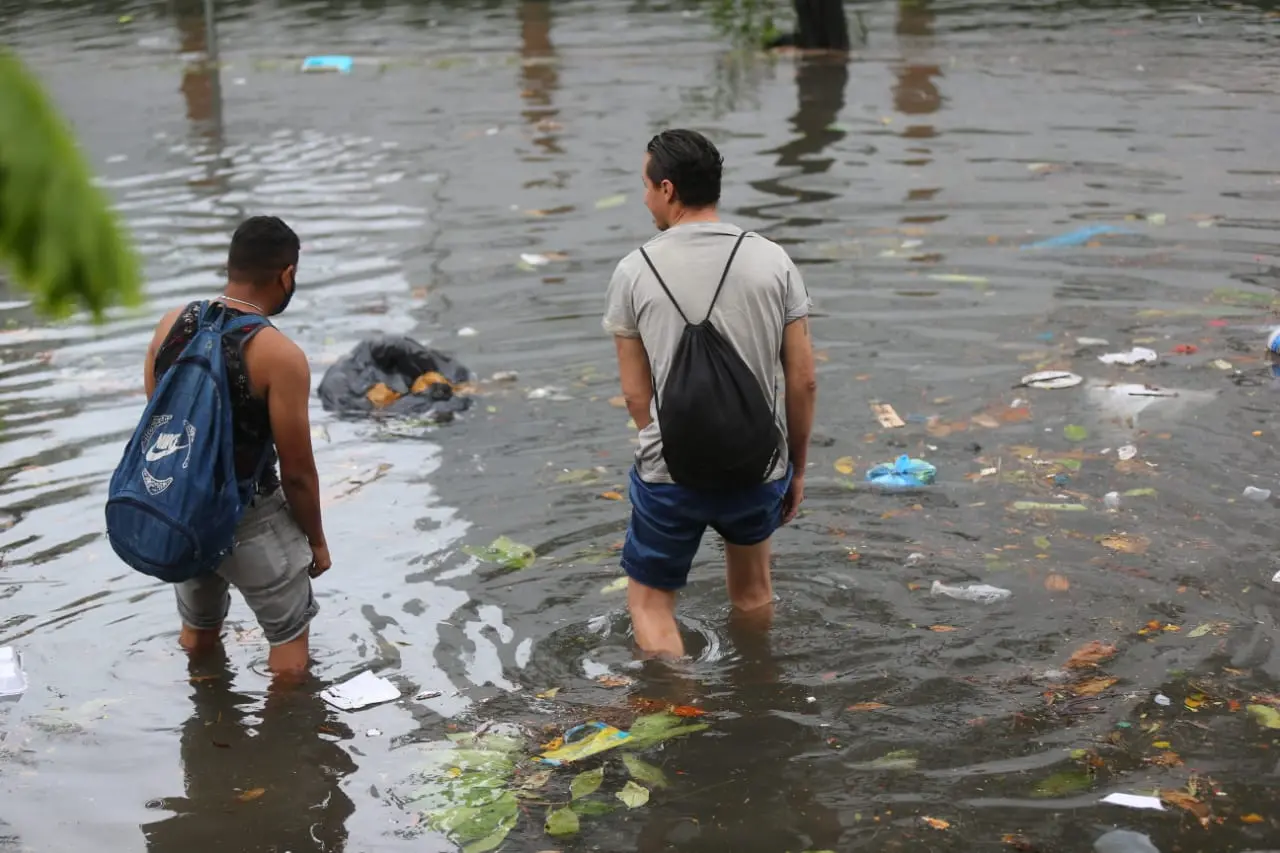 Pedestres atravessam avenida Heráclito Graça alagada em Fortaleza maio de 2021