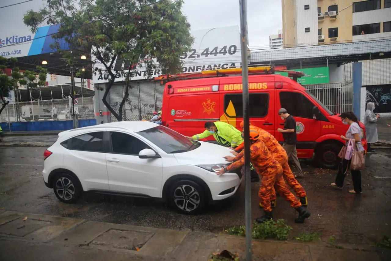 Equipe do Corpo de Bombeiros auxiliam carro que quebrou em via alagada de Fortaleza