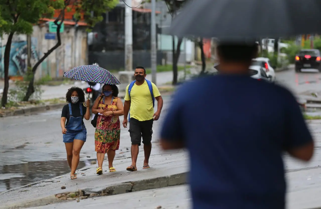 Pessoas se protegem da chuva em Fortaleza em maio de 2020