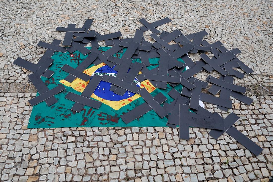 Bandeira do Brasil no chão com cruzes pretas em cima dela