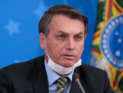 Bolsonaro com a máscara no queixo durante coletiva de imprensa