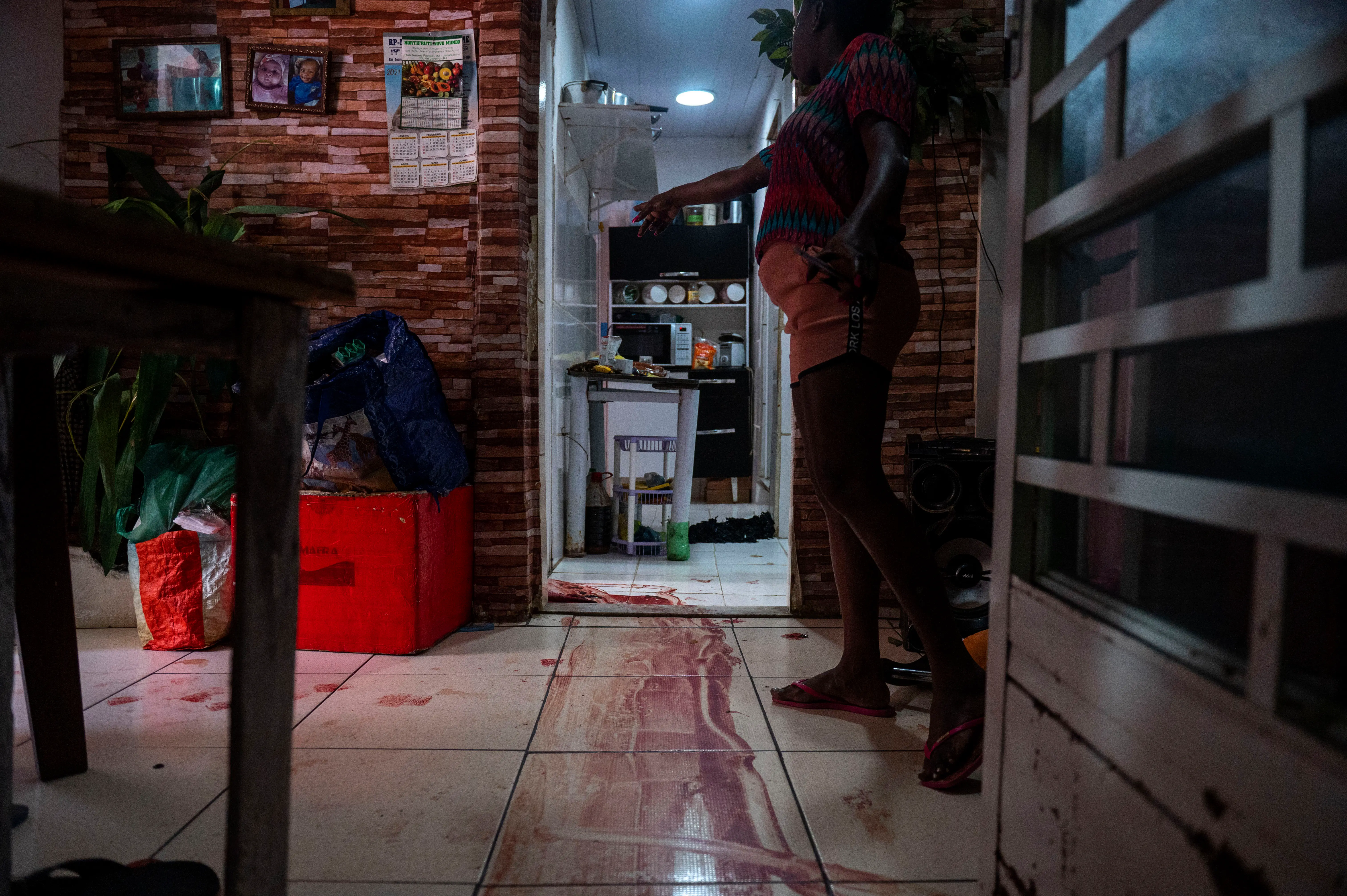 Uma mulher mostra a cena em que um suposto traficante de drogas foi morto pela polícia civil enquanto tentava escapar e correu para o quarto de sua filha de nove anos que testemunhou o tiroteio, na favela do Jacarezinho, Rio de Janeiro, Brasil, em maio 6, 2021.