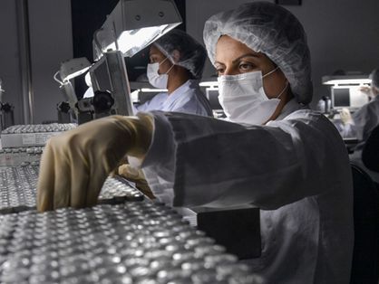 Técnicos de laboratório separando centenas de unidades da vacina CoronaVac