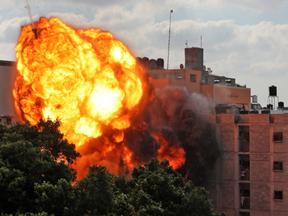 Uma foto tirada em 13 de maio de 2021 mostra uma bola de fogo engolfando o prédio Al-Walid, que foi destruído em um ataque aéreo israelense na cidade de Gaza no início da manhã.