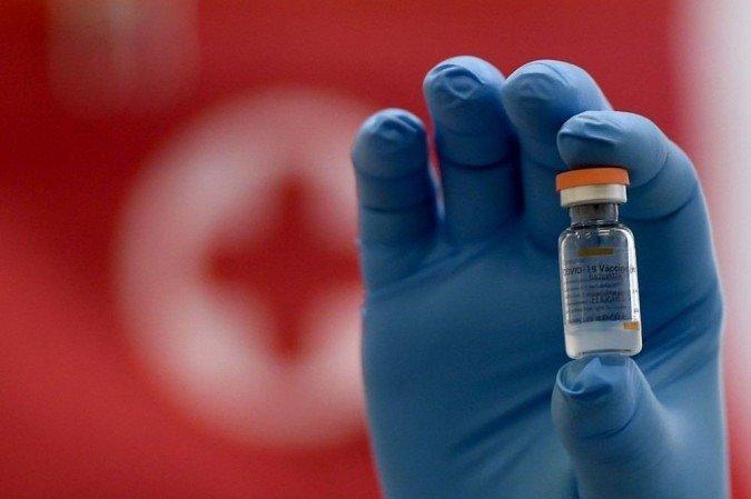 Profissional de saúde segura frasco da CoronaVac