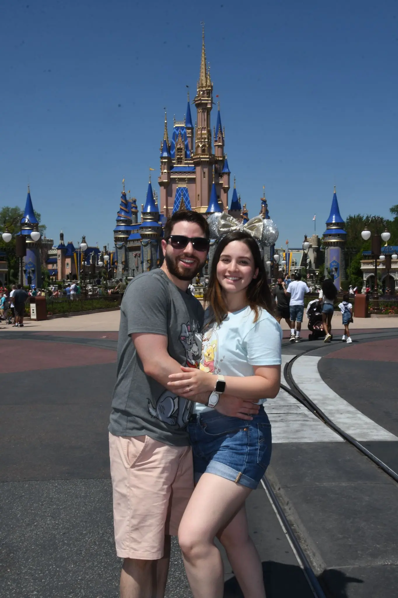 Foto de casal posando em frente de castelo da Disney