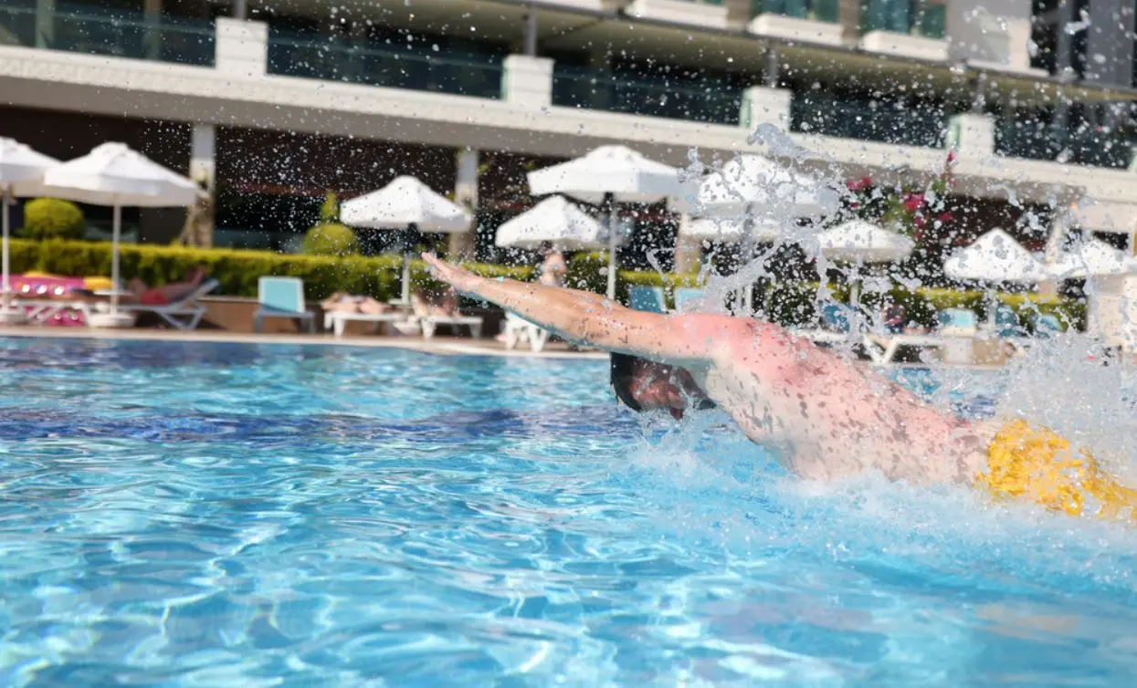 Pessoa nadando em piscina de hotel