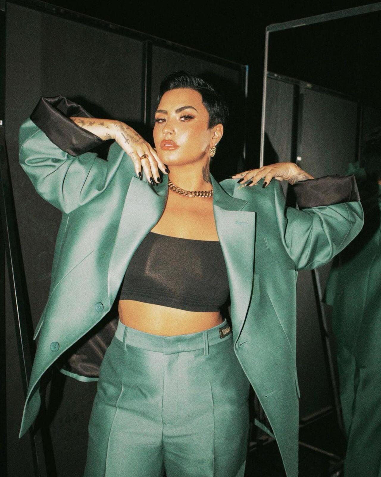 Demi Lovato com roupas nas cores verde e preta