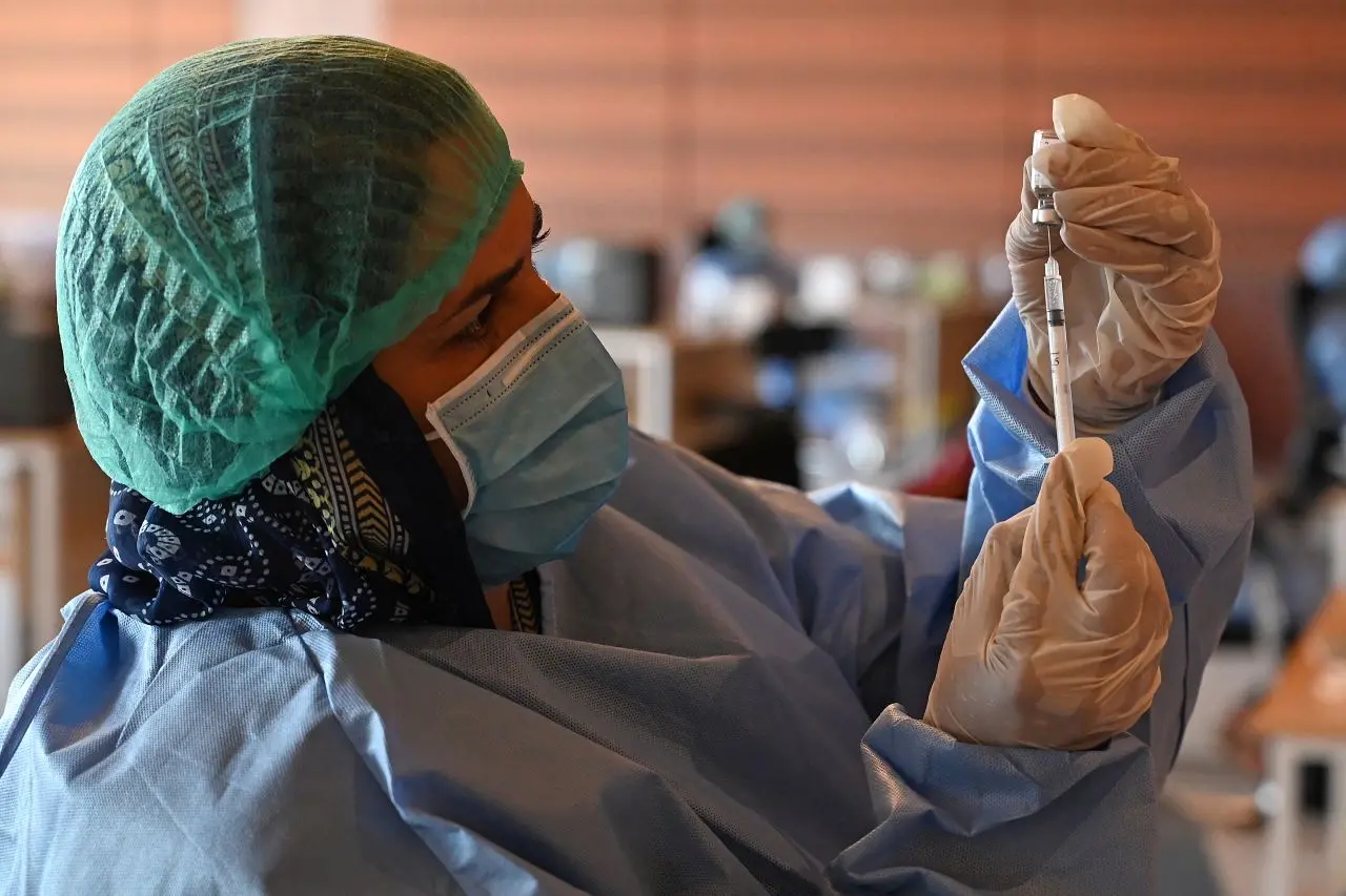 profissional de saúde segura seringa e dose da vacina convidecia