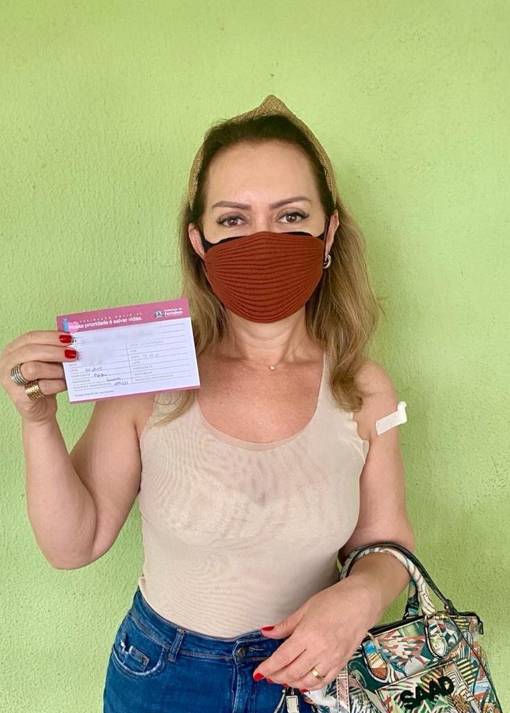 A paciente cardiopata Glucia Pinheiro com o seu carto de vacinao contra a Covid-19