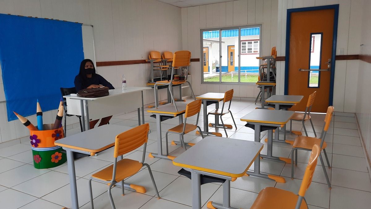 Sala de aula vazia, apenas com a professora