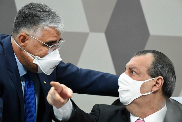 Presidente da CPI da Pandemia, o senador Omar Aziz conversa com o senador cearense Eduardo Girão e aponta para a frente durante sessão da CPI