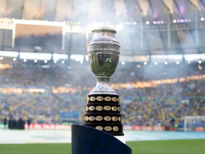 Taça da Copa América dentro de estádio de futebol