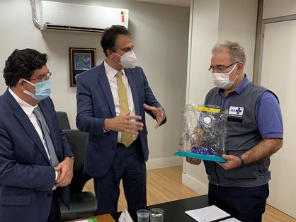 O ministro da Saúde, Marcelo Queiroga, segura uma unidade do Capacete Elmo enquanto o governador Camilo Santana e o secretário de Saúde, Dr. Cabeto, apresentam o equipamento