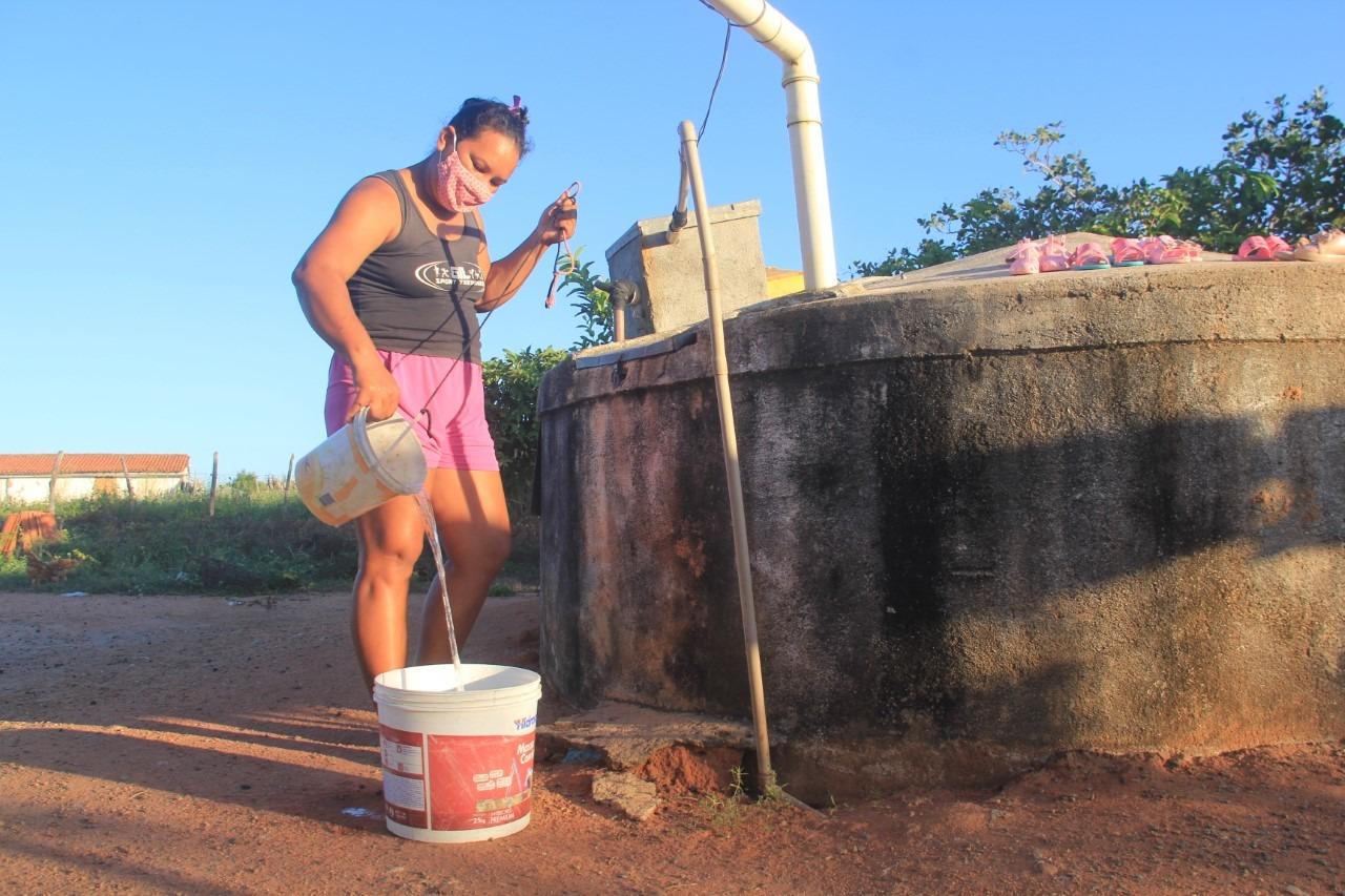 Maria Cardoso retira o que sobrou de água da chuva na cisterna.