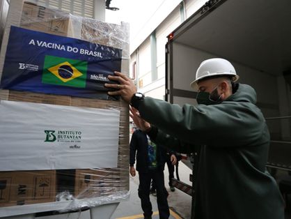 homem transporta caixa com vacinas coronavac