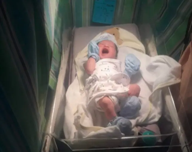 Criança em berço na maternidade após nascimento