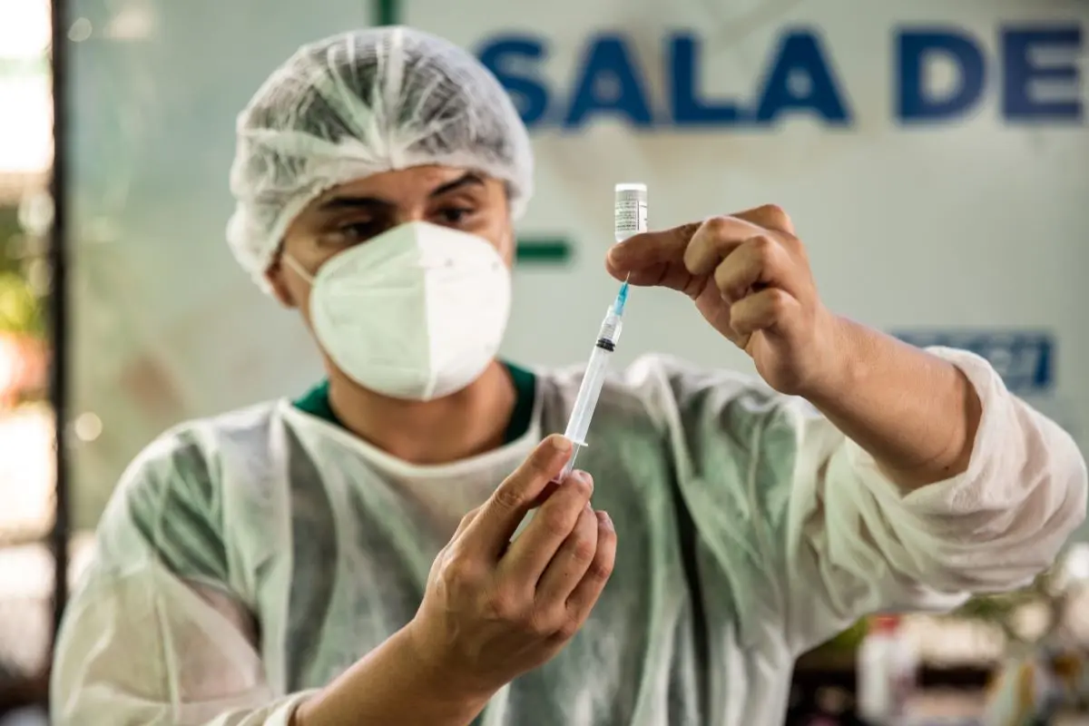 profissional da saúde preparando dose de vacina contra a covid-19