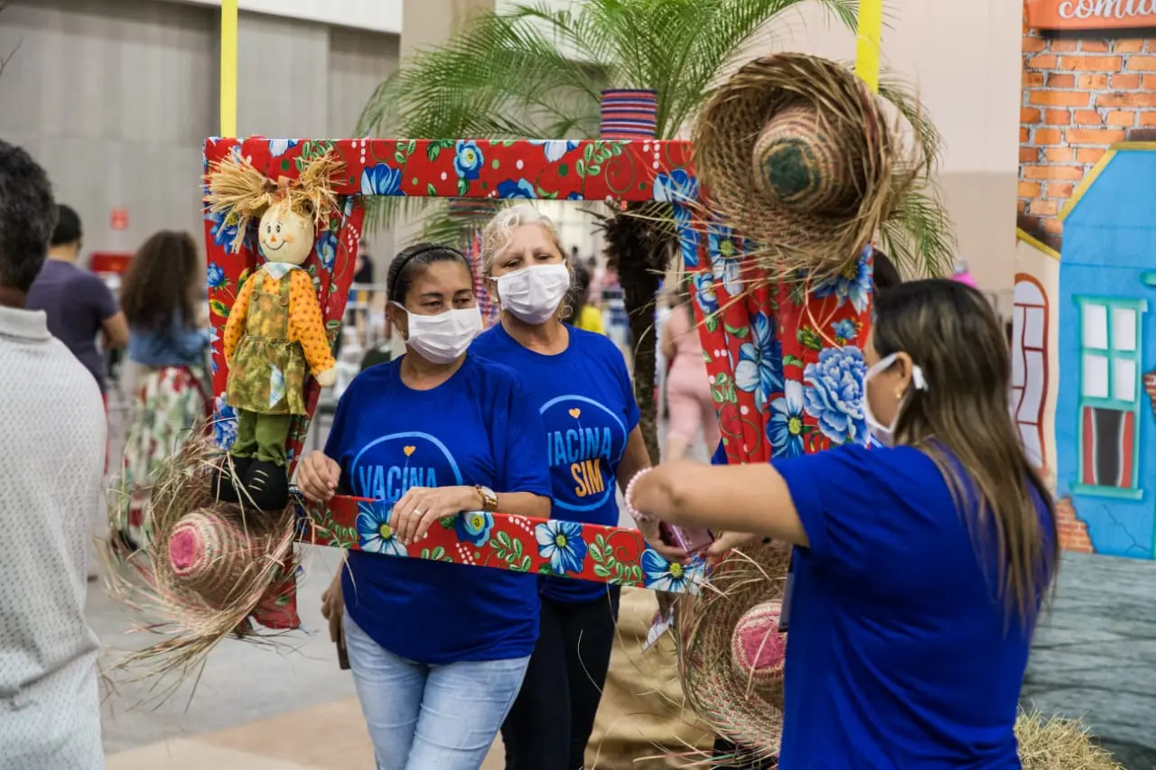 pessoas tirando foto com decoração junina no centro de eventos