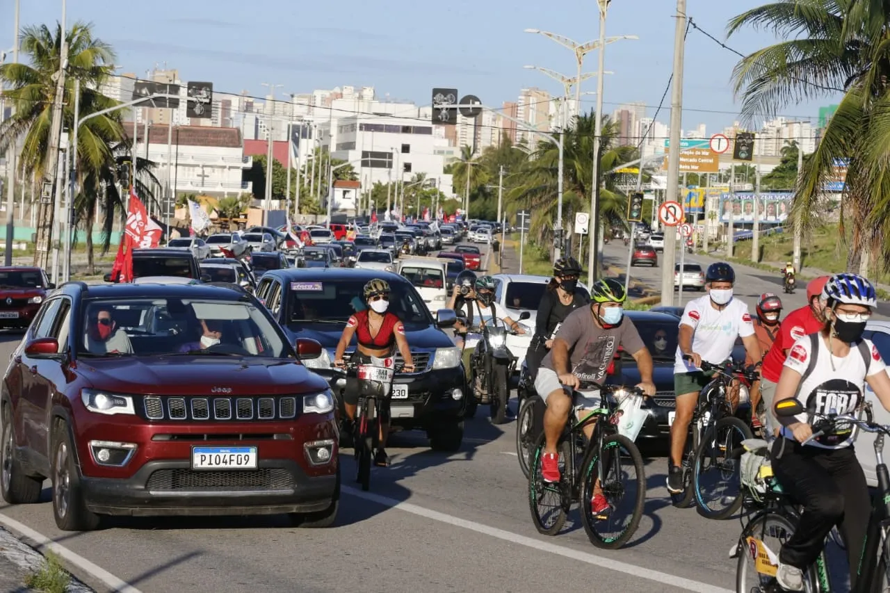 Ciclistas presentes no ato carregam adesivos contra o presidente.