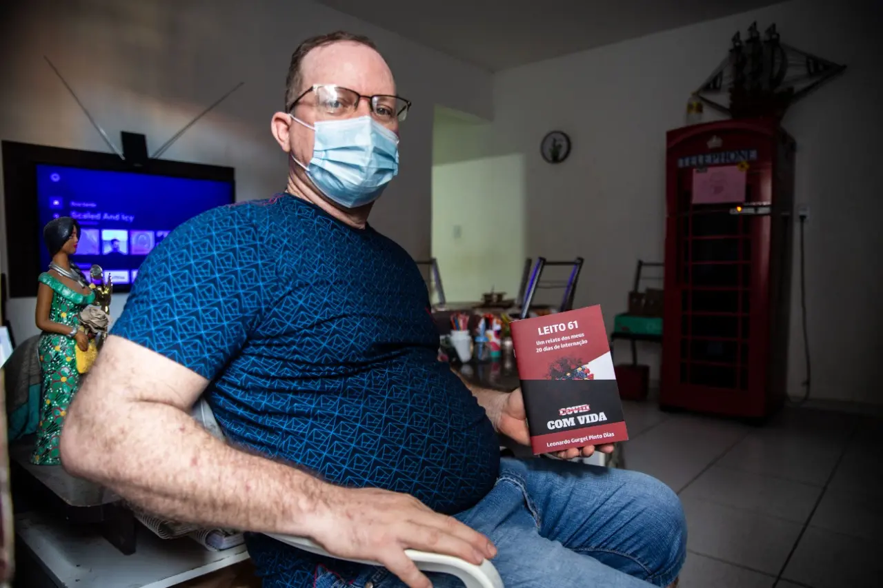 foto de um homem segurando um livro