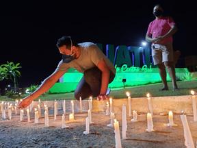 Homem acende velas em Iguatu em homenagem às vítimas da Covid-19 no município