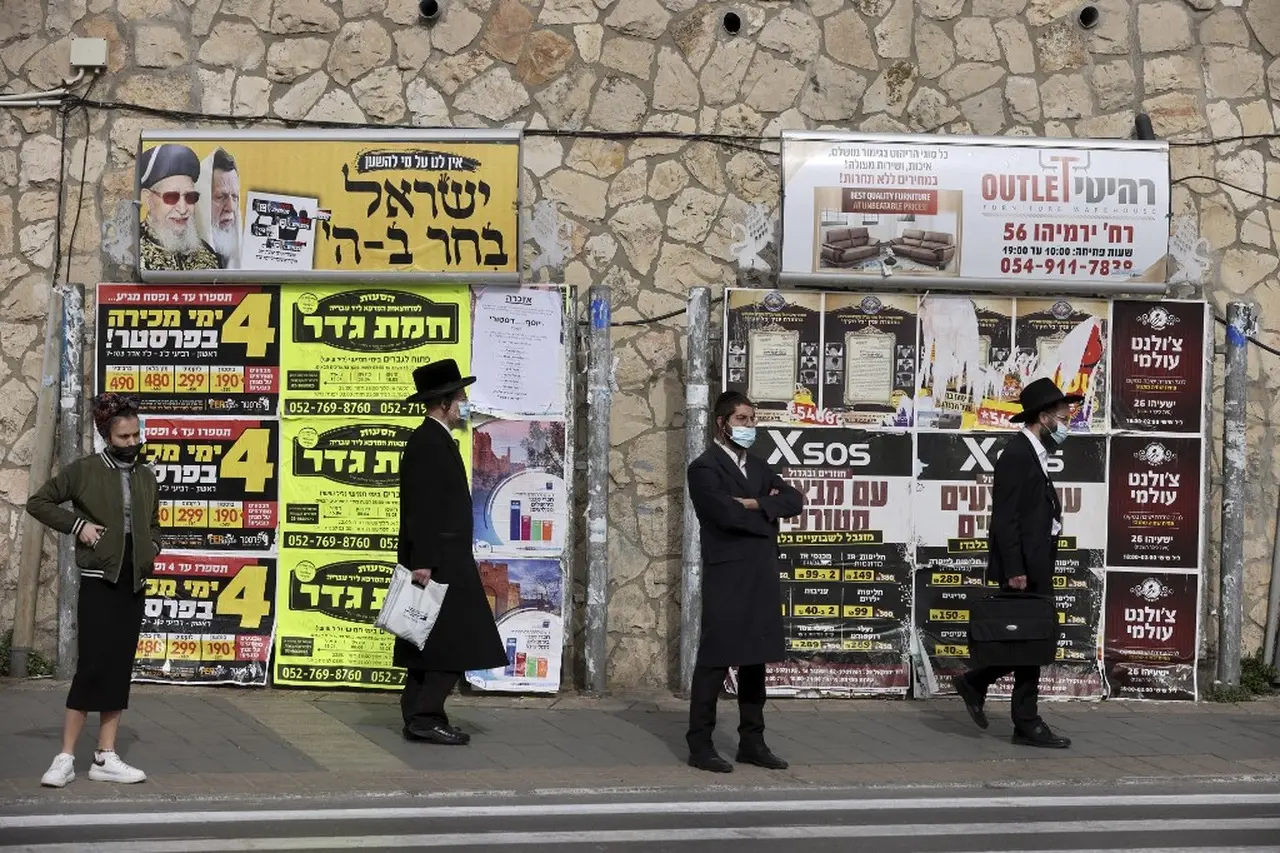 Pessoas usando máscara em parada de ônibus em Israel