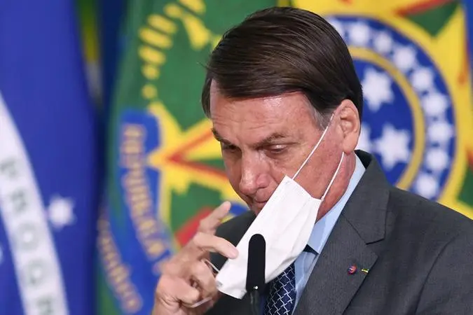 Presidente Jair Bolsonaro ajustando a máscara no rosto