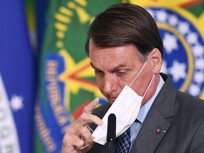 Presidente Jair Bolsonaro ajustando a máscara no rosto