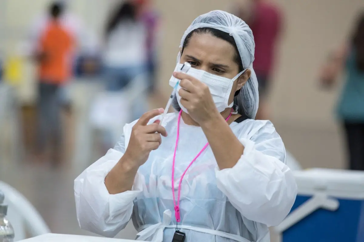 enfermeira preparando dose de vacina da covid-19 para ser aplicada