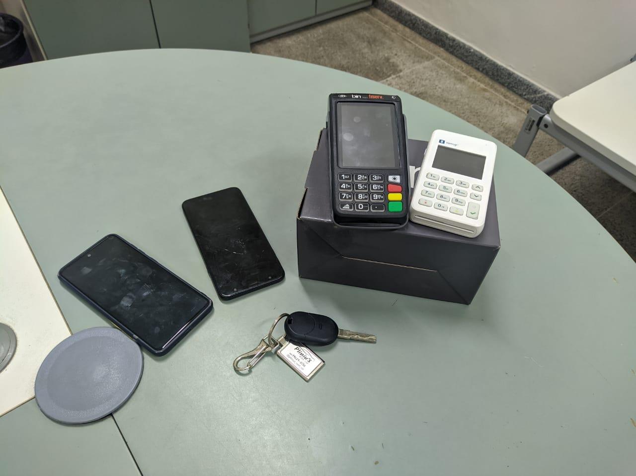 Itens apreendidos pela Polícia Civil. Duas máquinetas de cartão, dois celulares e uma chave de carro