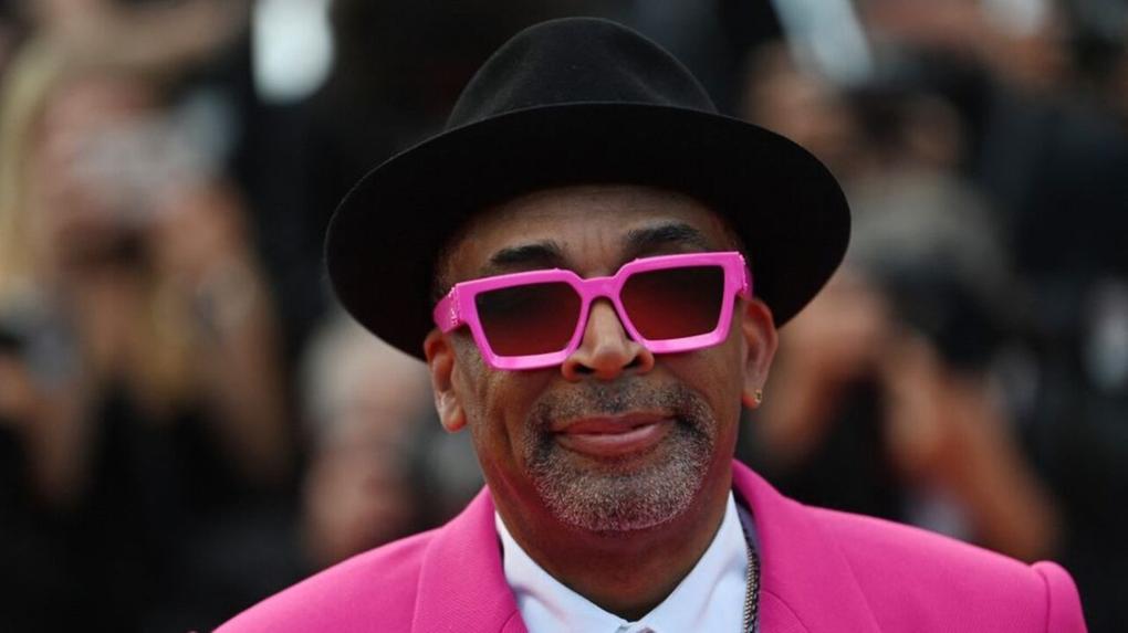 Spike Lee usando blazer e óculos de cor rosa, além de chapéu preto