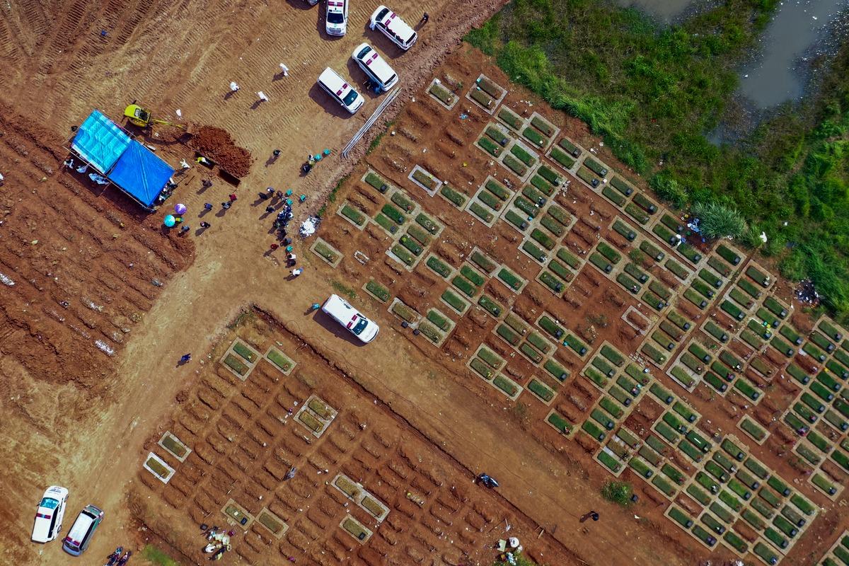 Esta imagem aérea mostra trabalhadores enterrando corpos de vítimas d aCovid-19 no cemitério público de Pedurenan em Bekasi, Java Ocidental, em 7 de julho de 2021.
