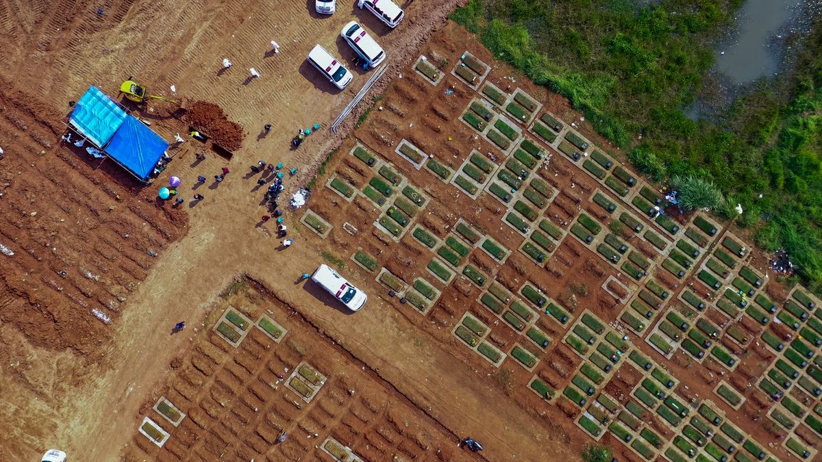 Esta imagem aérea mostra trabalhadores enterrando corpos de vítimas d aCovid-19 no cemitério público de Pedurenan em Bekasi, Java Ocidental, em 7 de julho de 2021.
