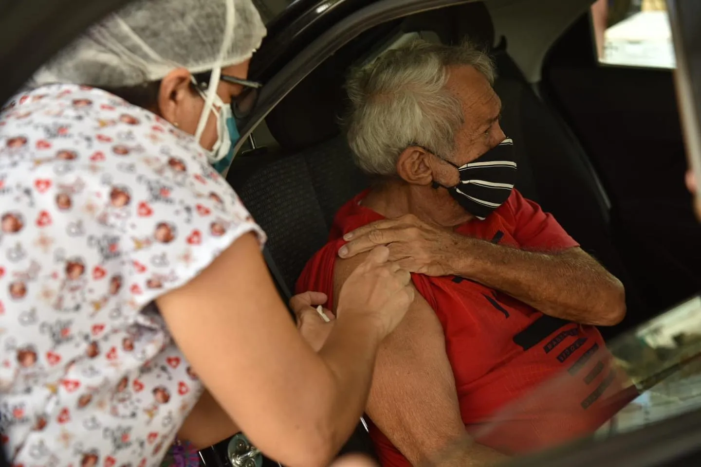 Idoso é vacinado em drive-thru de Caucaia.