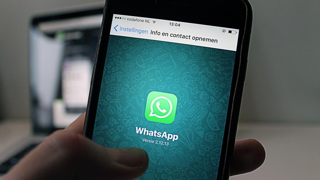 mão segurando celular mostrando ícone do whatsapp