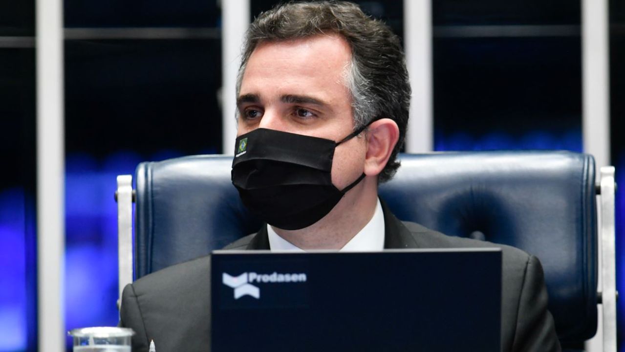 Rodrigo Pacheco vestindo máscara e usando notebook no Senado