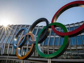 Imagem com símbolo olímpico na frente da Vila Olímpica de Tóquio