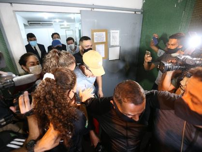 de boné, dj ivis deixa a delegacia metropolitana do eusébio cercado por policiais e profissionais da imprensa
