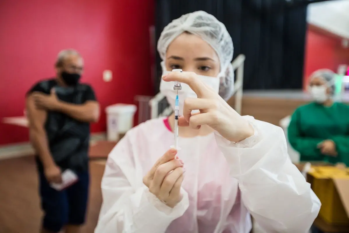Enfermeira preparando aplicação de dose de vacina contra a Covid-19