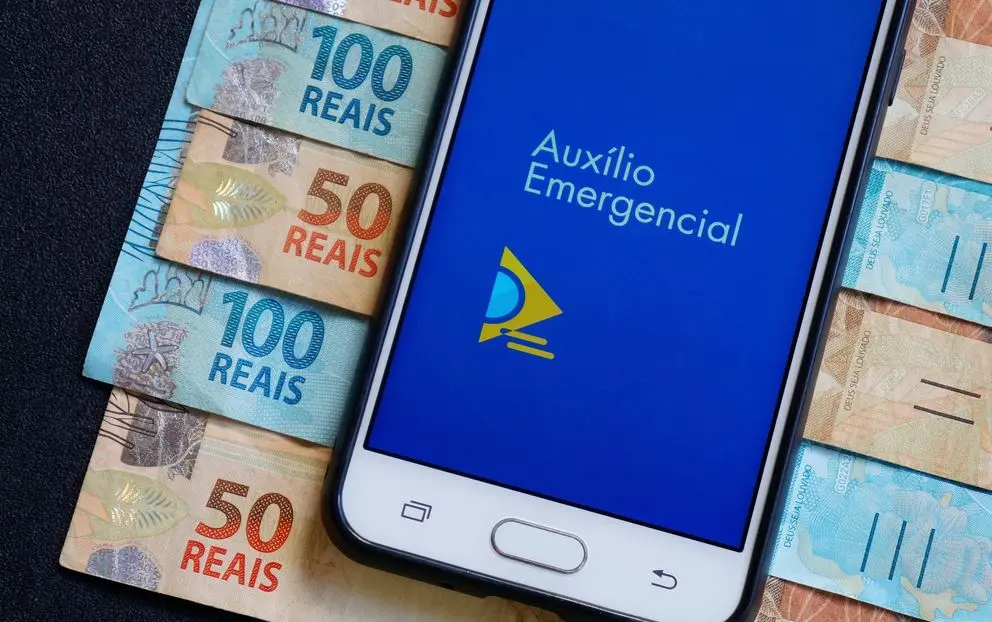 Celular com aplicativo do auxílio emergencial sobre valor em dinheiro