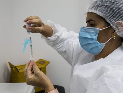 Profissional de saúde preparando aplicação de dose de vacina contra a covid-19