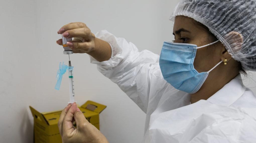Profissional de saúde preparando aplicação de dose de vacina contra a covid-19