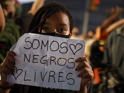 menina segurando cartaz contra o racismo