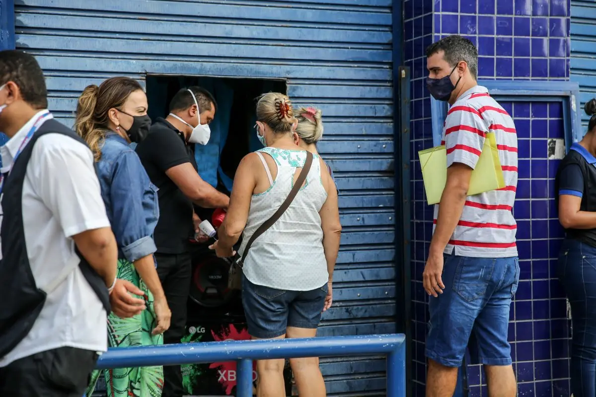 Clientes tendo temperatura aferida na entrada de loja em fortaleza