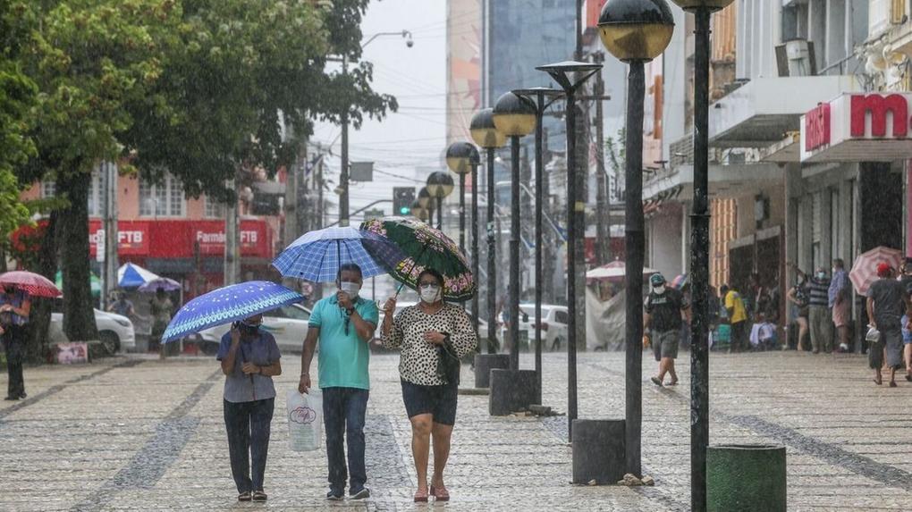 Pessoas de máscara na Praça do Ferreira em dia de chuva