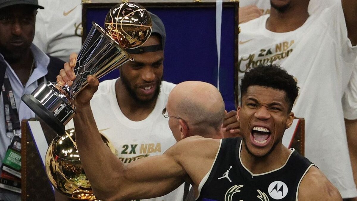 Giannis Antetokounmpo segura o troféu de campeão da NBA e comemora vitória