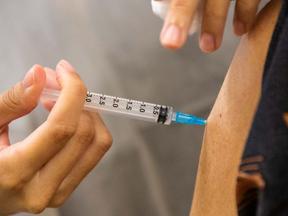 Enfermeiro aplica vacina em braço de idoso em Fortaleza