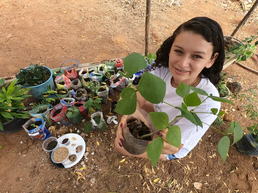 menina segurando muda de planta